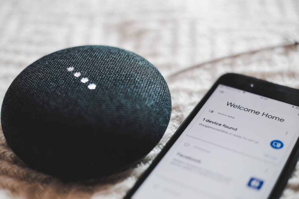 Active gray Google Home Smart Speaker pairs with a smartphone that reads “Welcome home